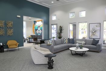 A living room with a grey sofa, a yellow chair, and a coffee table.